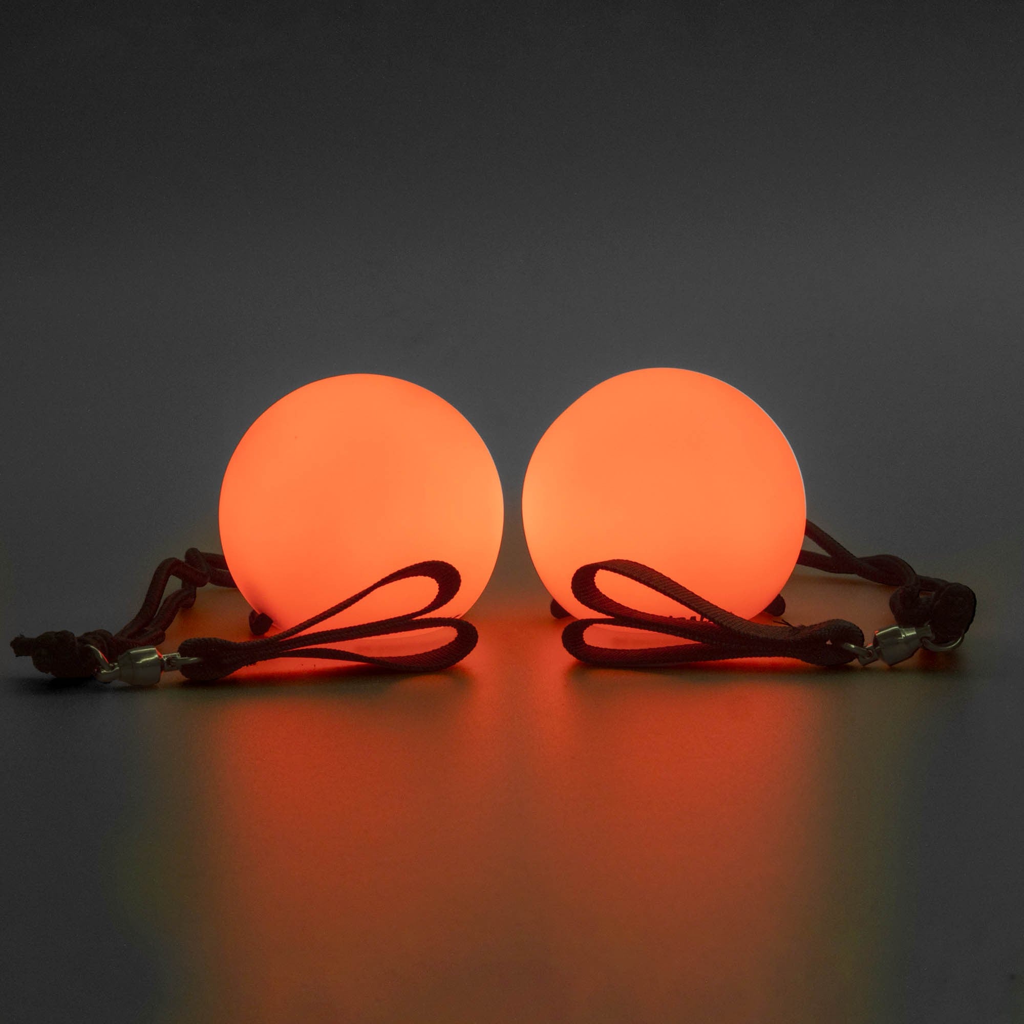 Spinballs glow poi glowing orange with a dark background