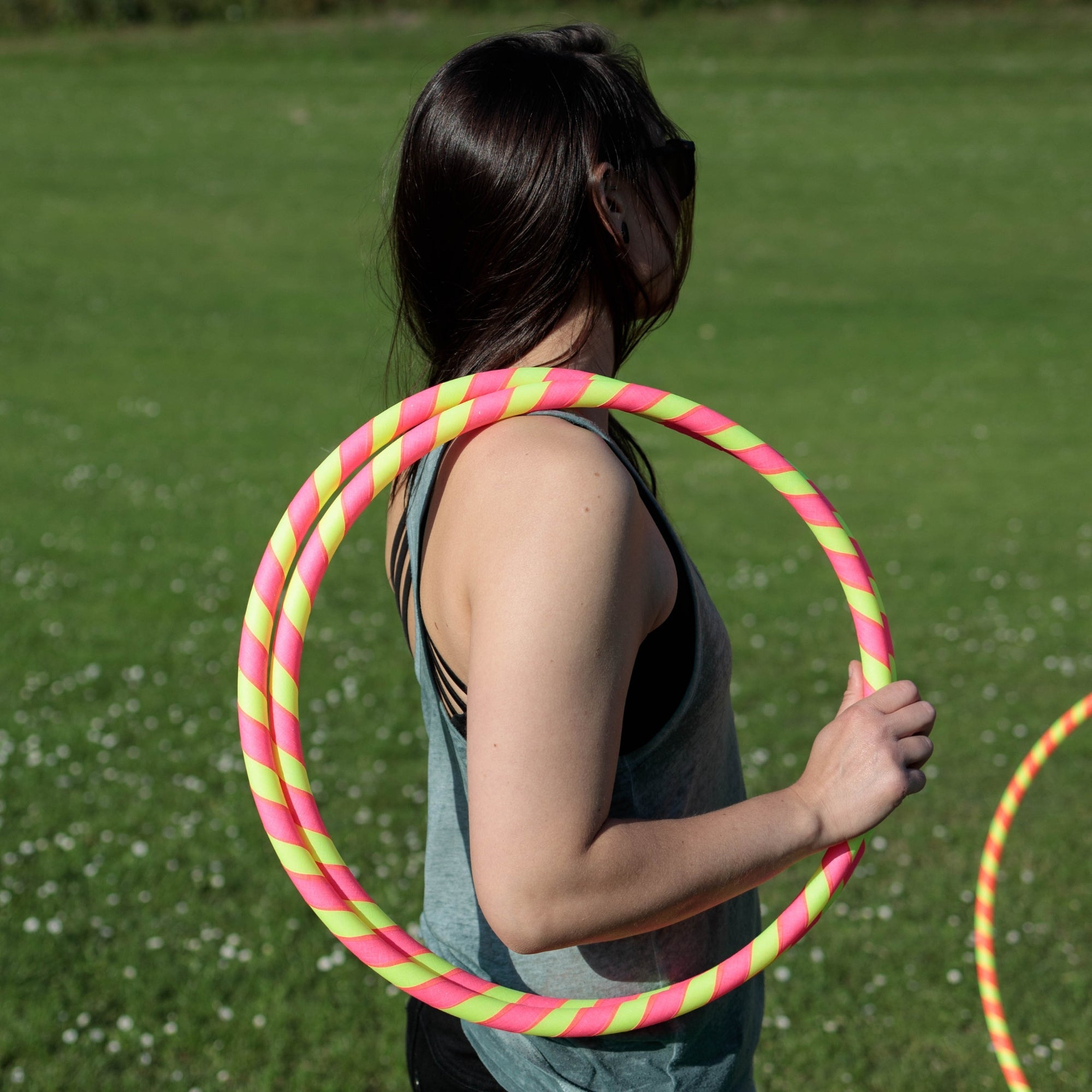 a person holding a coiled hoop over the shoulder