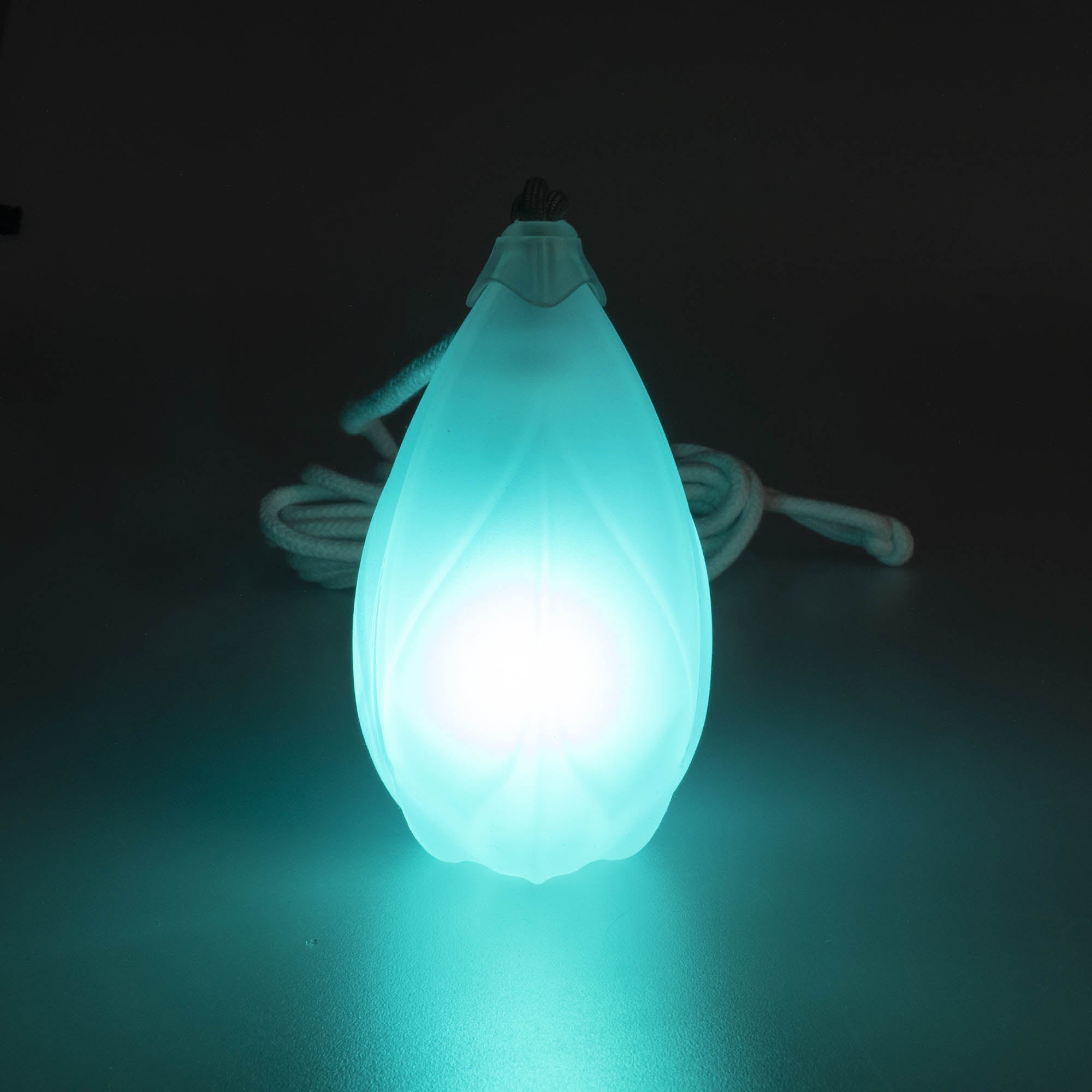 Flowtoys pod dart V2 glowing blue in a dark background with cord behind 