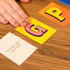 Colorful number cards on a wooden surface with a hand reaching for one of them.