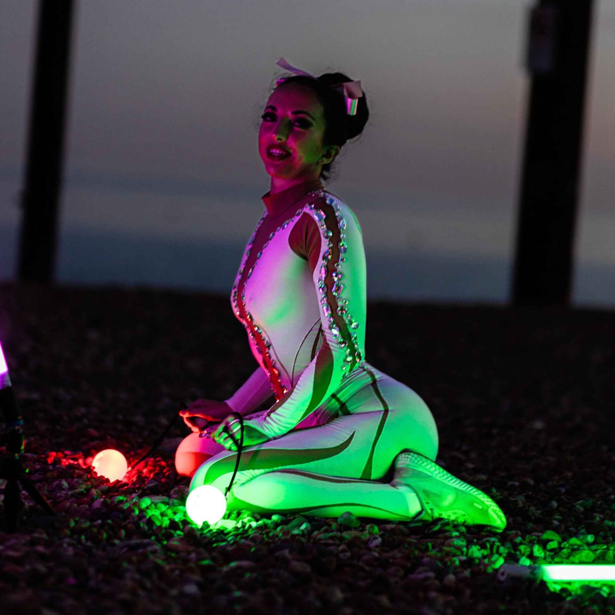 a performer illuminated by glow poi