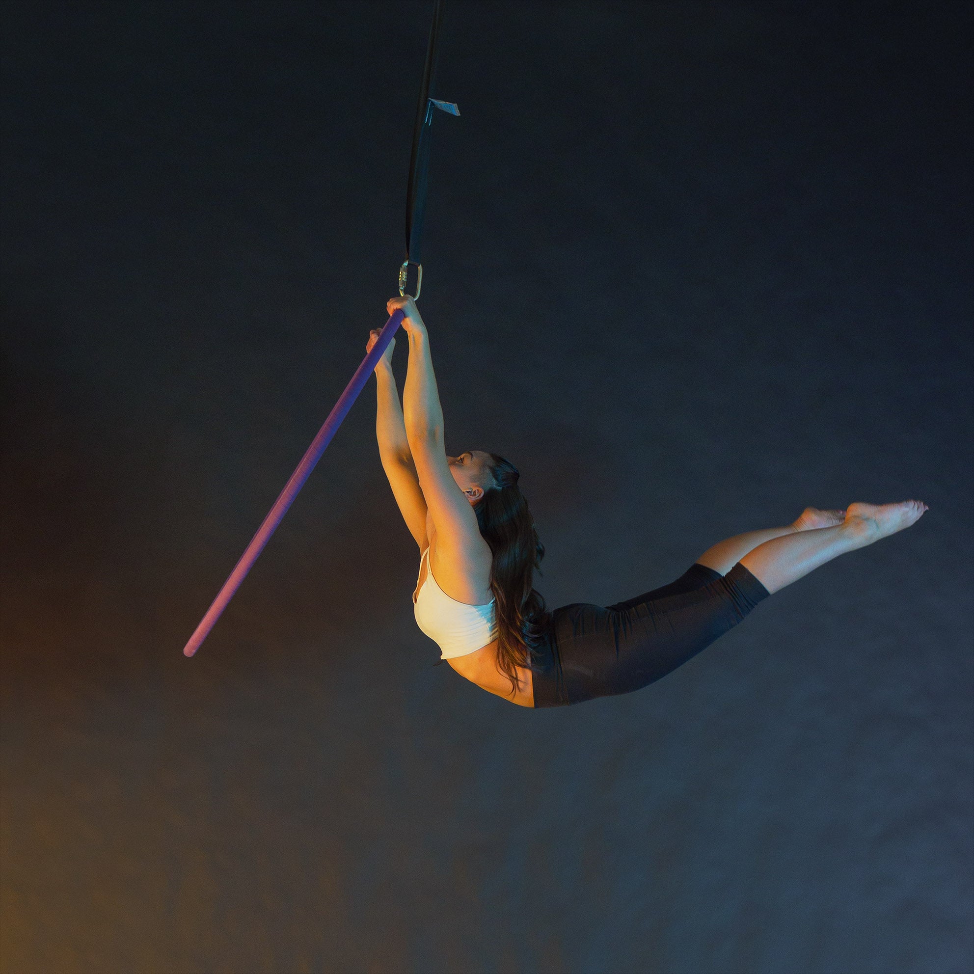 Performer hanging from 1 point aerial hoop