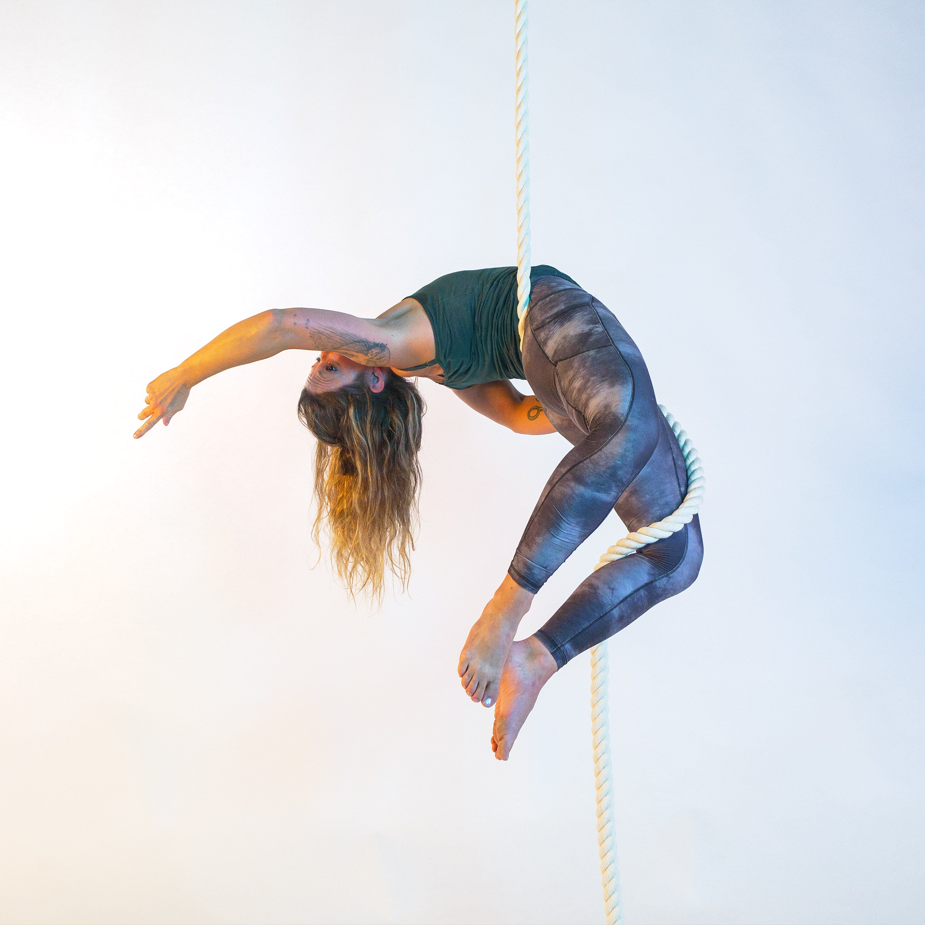 image of a performers in a back balance on a white 3-ply rope
