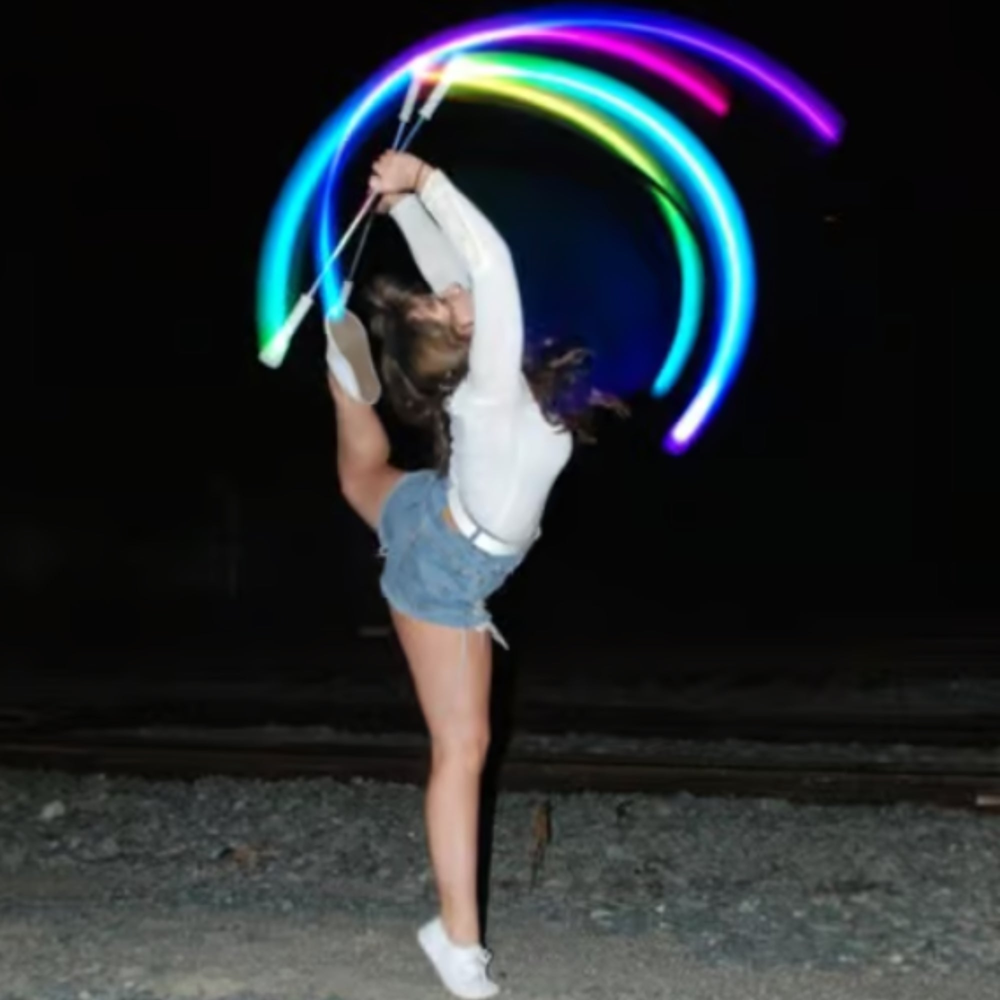 a person spinning 2 batons with light trails