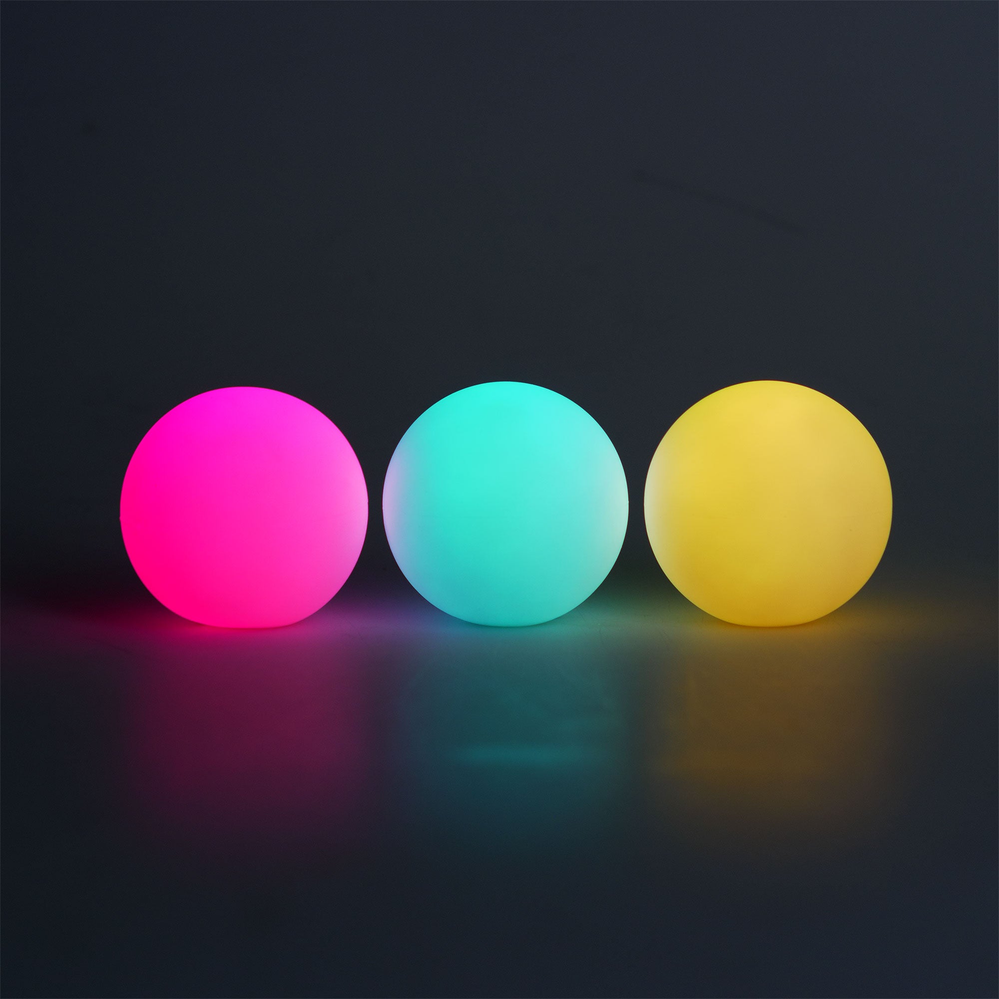 Three colorful glowing balls (pink, blue, yellow) on a dark background